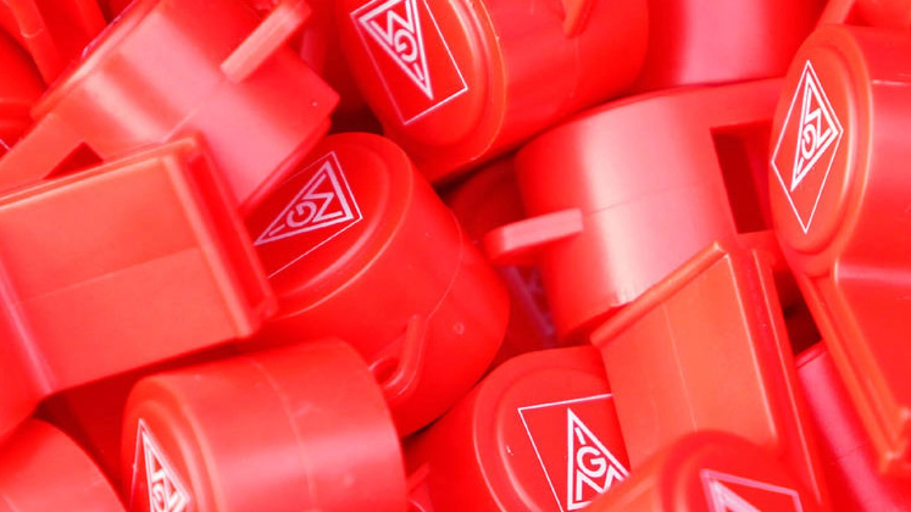 Viele rote Trillerpfeifen mit dem Logo der IG Metall. 